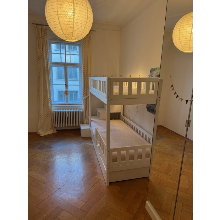 Łóżko piętrowe ze schodami i barierką zabezpieczającą górny poziom